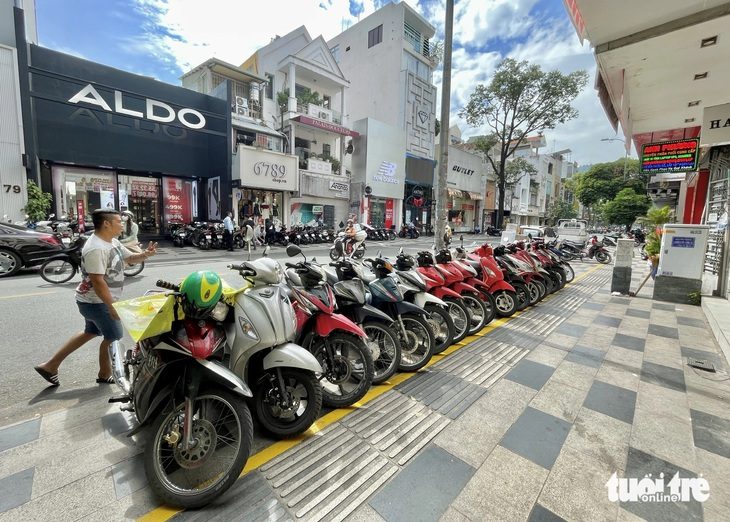 9 trường hợp tạm dùng vỉa hè phải đóng phí ở TP.HCM- Ảnh 1. Việc rà soát, tiến hành thu phí sử dụng tạm lòng đường, vỉa hè ở TP.HCM hướng đến quản lý trật tự đô thị tốt hơn. Trong ảnh: xe máy xếp hàng ngăn nắp trong khu vực kẻ vạch để xe tự quản (đường Nguyễn Trãi, quận 1, TP.HCM) - Ảnh: CHÂU TUẤN